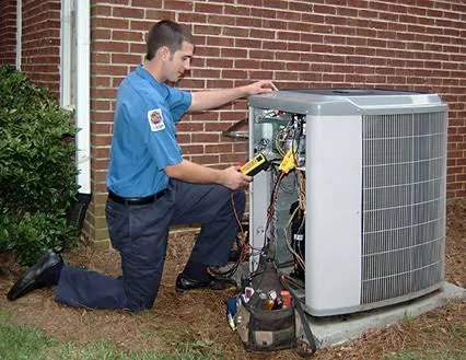 Technician performing maintenance on a residential condenser